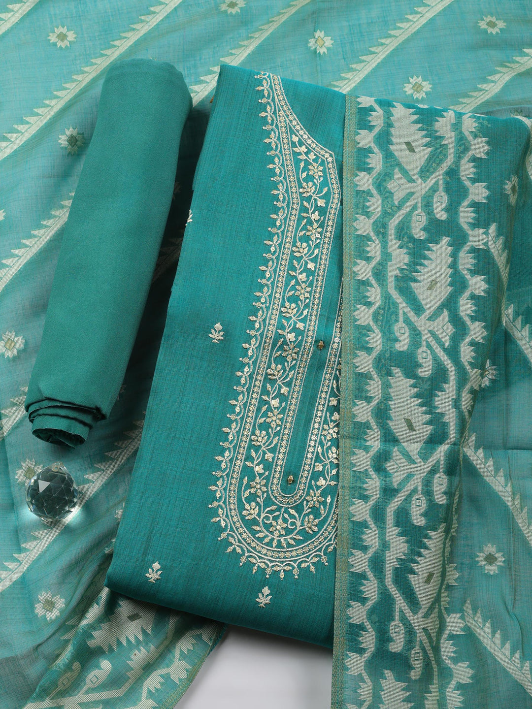 Teal fabric with white embroidery on a matching fabric background